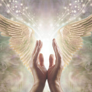 Male hands reaching up into a beautiful pair of golden Angel wings with white light and sparkles flowing  between, against a warm ethereal energy formation background